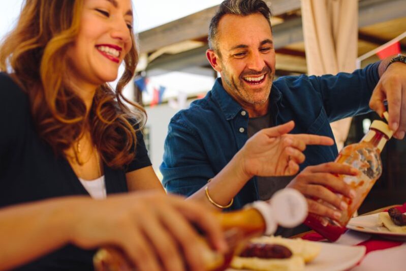 Couple enjoying local food at an outdoor restaurant on the water